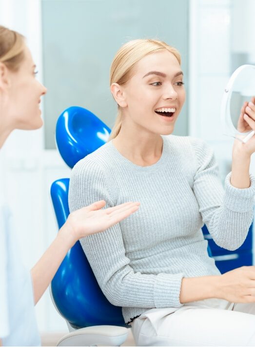 Woman beaming at her new smile after choosing cosmetic dentist in Los Angeles