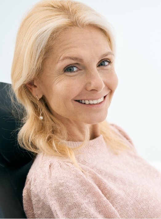 Older woman in dental chair smiling after cosmetic dental bonding in Los Angeles