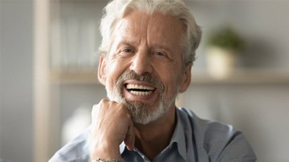 : a man smiling after receiving his new dentures