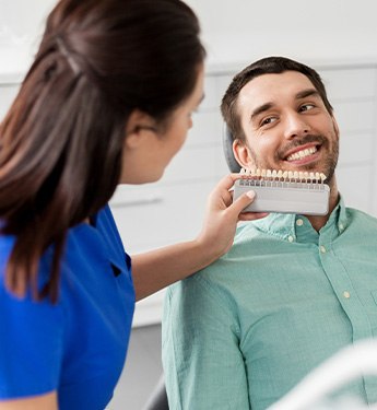 Patient smiling in dental chair after teeth whitening