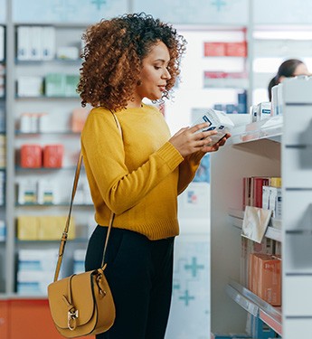 Patient browsing teeth whitening options at a pharmacy