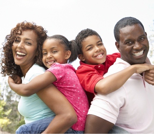 Family of four smiling outdoors