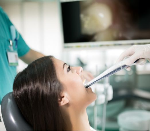 Dental patient having intraoral photos of her mouth taken by dentist