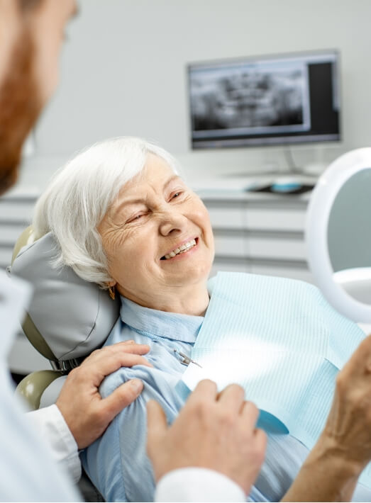 Senior woman admiring her new smile with All on 4 dental implants in Los Angeles
