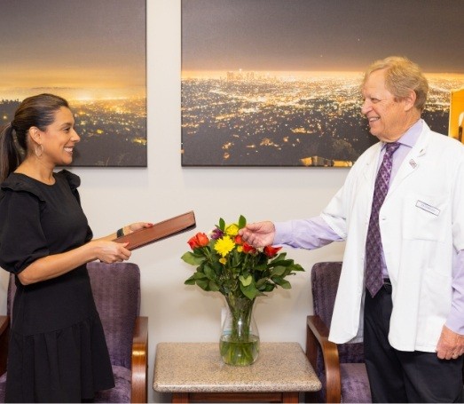 Doctor Les Latner talking with dental team member in reception area