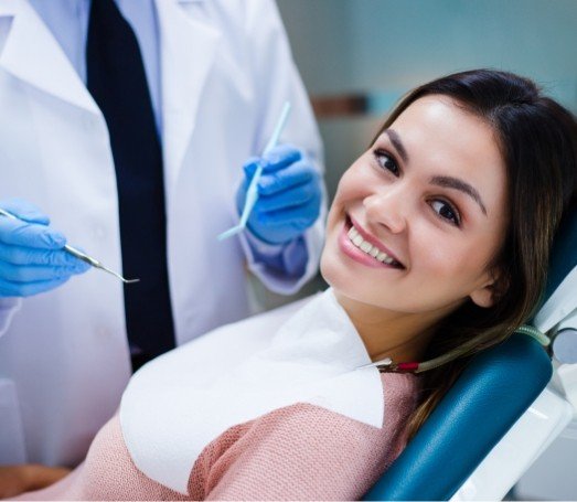 Young woman smiling before receiving dental exam