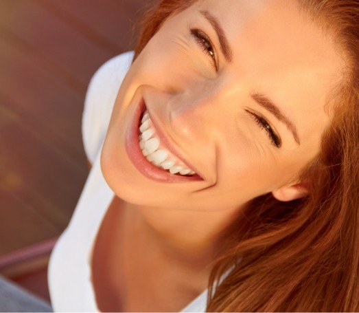 Redheaded young woman smiling up at the camera