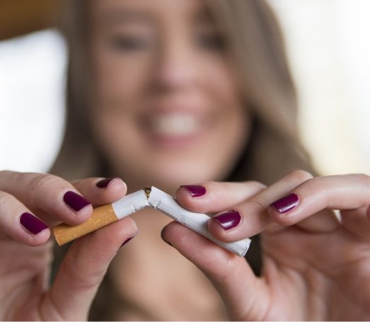 Woman breaking a cigarette in half