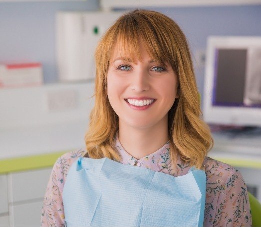 Woman with strawberry blonde hair sitting in dental chair