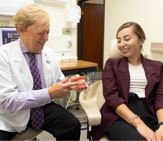 Doctor Latner showing a model of the mouth to a dental patient