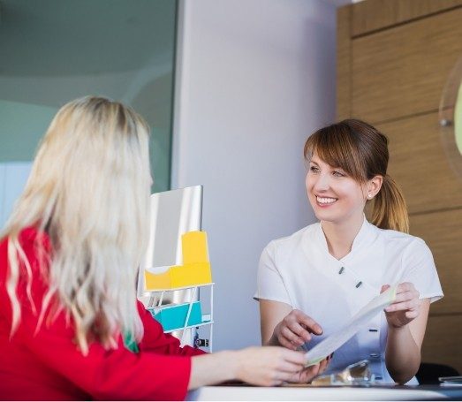 Dental team member showing a paper to a patient