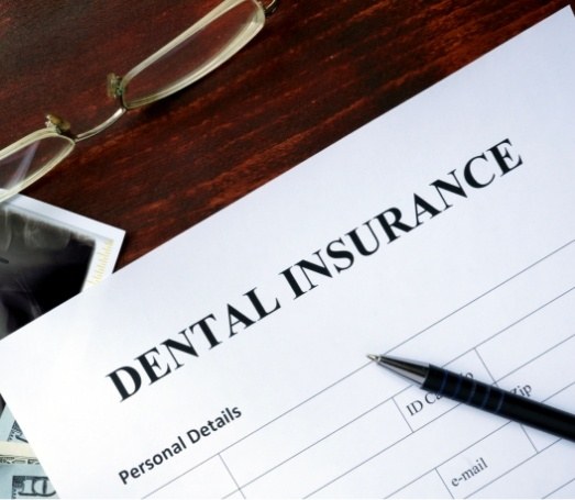 Dental insurance form on dark wood table