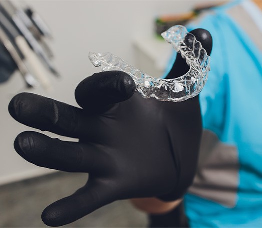 Dentist holding clear aligner