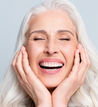 laughing senior woman touching her face