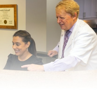 Los Angeles California dentist Doctor Les Latner looking at computer screen with dental team member