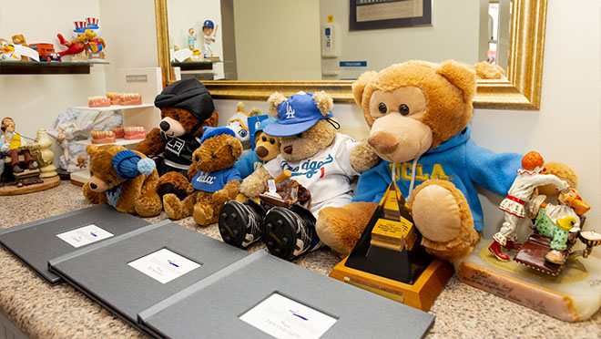 Shelf full of teddy bears in various outfits