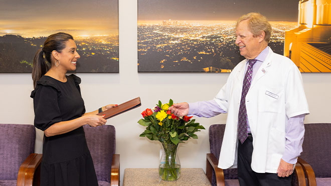 Doctor Latner talking with dental team member holding clipboard