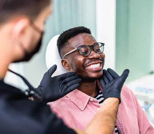 Dentist looking at smiling patient's teeth