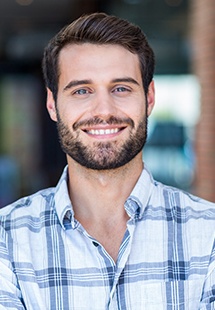 Smiling man in blue and white plaid shirt