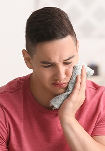 Man holding cold compress to his cheek