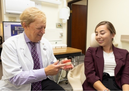 Los Angeles California dentist Doctor Les Latner showing a denture to a patient