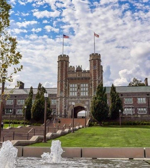 Brick academic building with staircase and pond in foreground