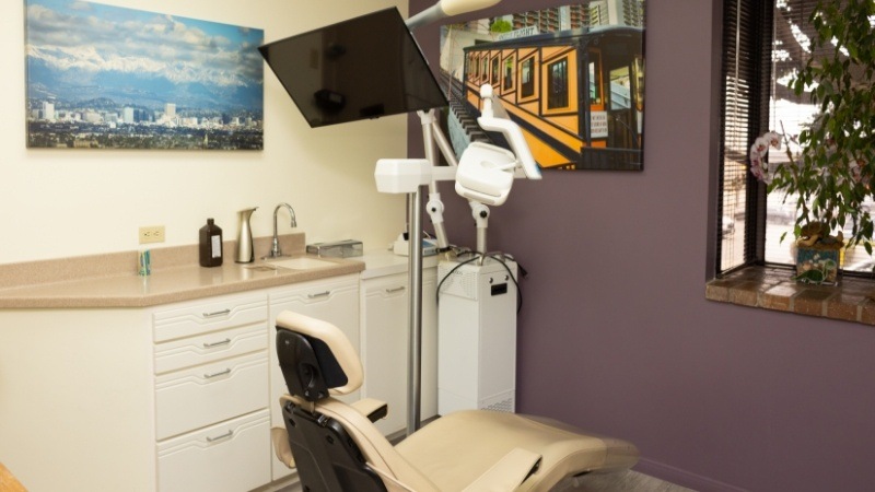 Dental exam room with photo of city and mountain on the wall