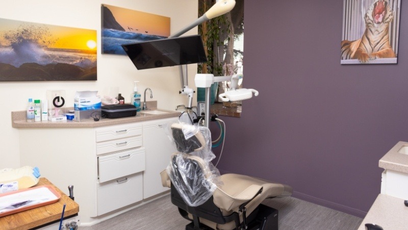 Dental exam room with photos of the beach at sunset on wall