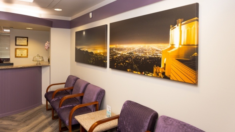 Photos of city lights at night on wall of dental reception area