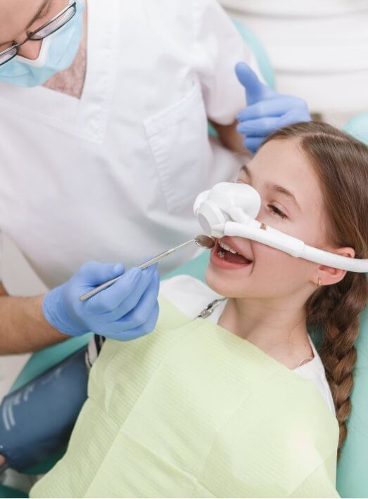 Young girl receiving dental care thanks to oral conscious sedation dentistry