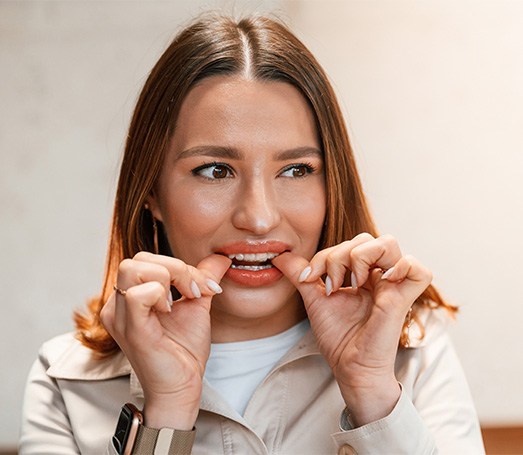 Patient putting on clear aligner in treatment room