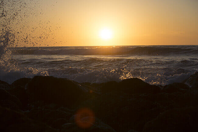 Sun setting over rocky shoreline