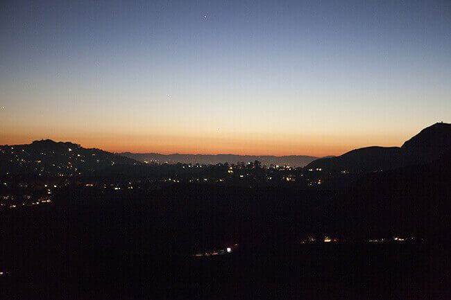 Silhouette of city skyline with mountains at dusk