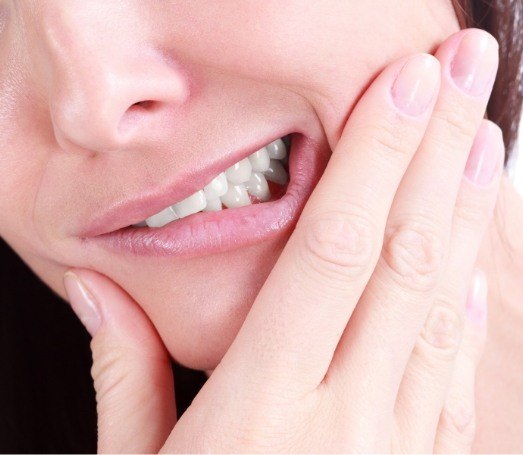 Close up of person holding their jaw in pain