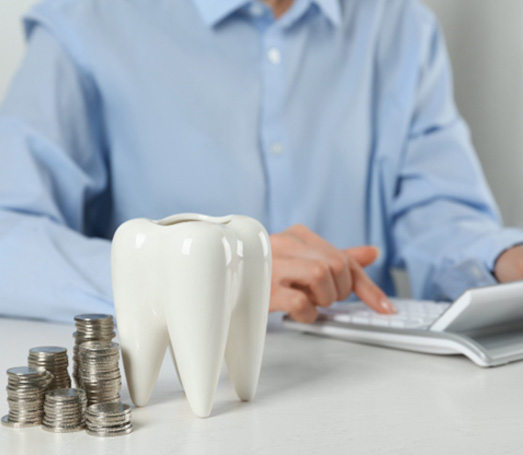 Person with calculator and change determining the cost of root canal treatment in Los Angeles 