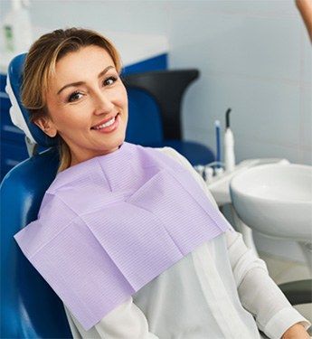 Woman smiling while sitting in treatment chair
