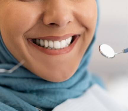 Close up of woman with light blue hijab receiving a dental exam