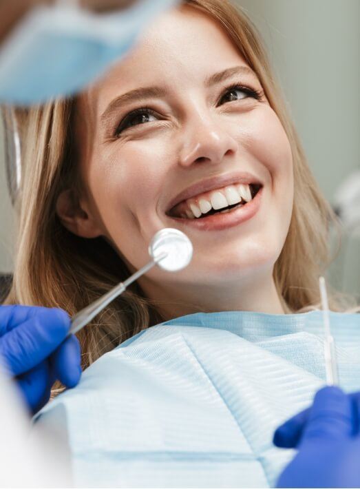 Woman smiling at her dentist after getting tooth colored fillings in Los Angeles