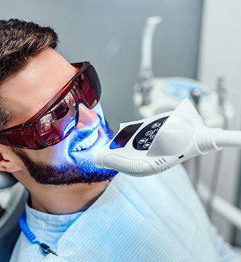 Man undergoing teeth whitening procedure in dental office
