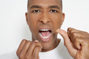 Man flossing teeth with tips from the los angeles dentist Les Latner and the Westside dental Associates team