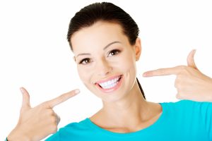 woman pointing at teeth smiling