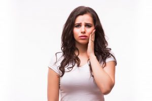 woman holding her face in pain