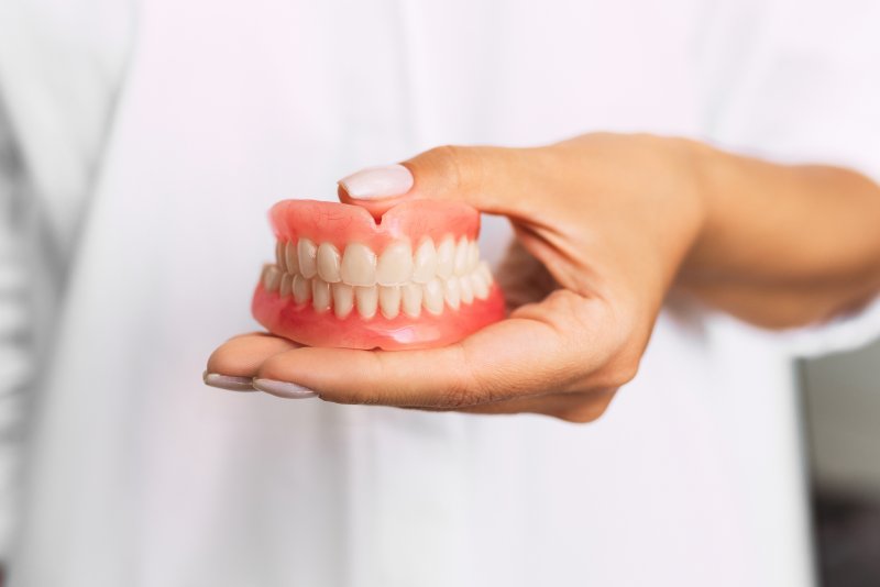 Dentist holding dentures