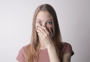 Woman covering her mouth before teeth whitening in Los Angeles