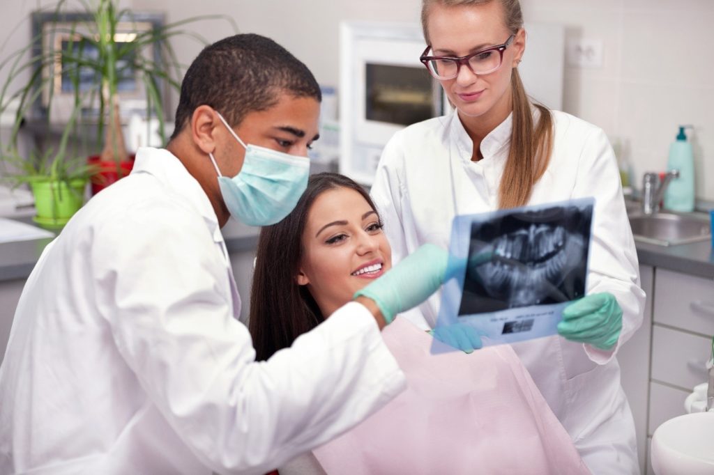 patient viewing x-ray with dentists 