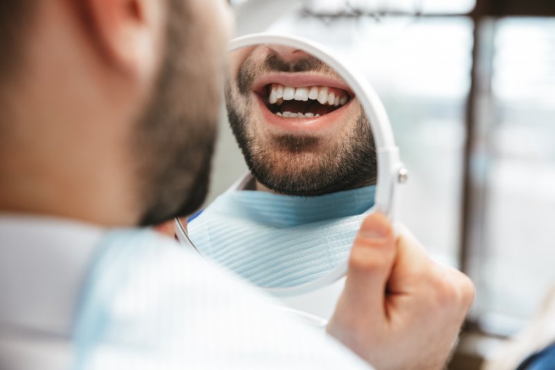 A man at the dentist looking at his new dental filling