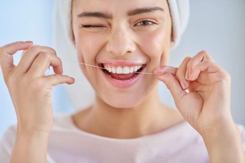 A woman flossing her teeth